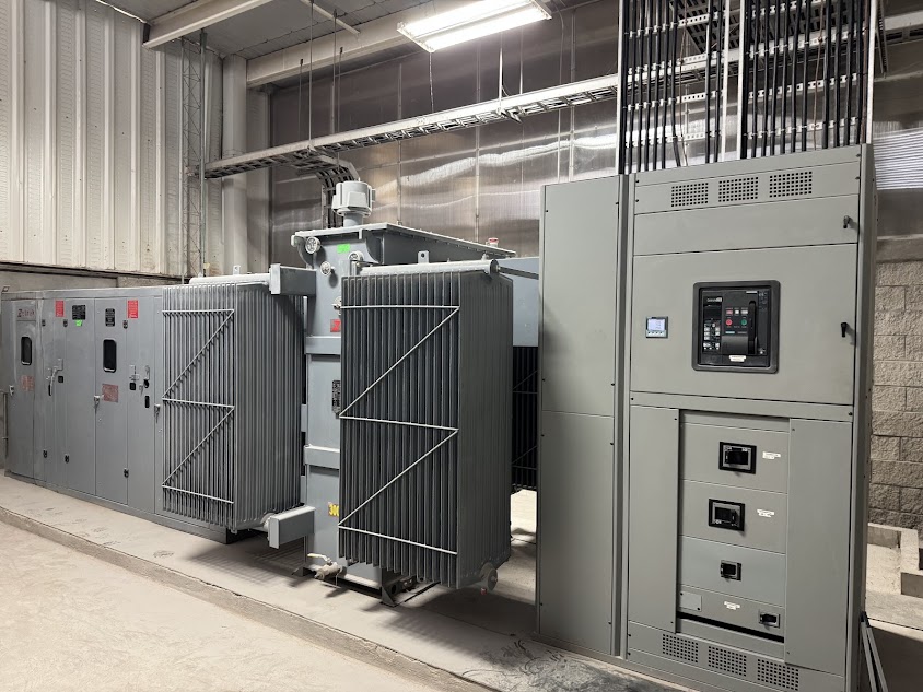 Cuarto eléctrico industrial con transformador y tablero de control etiquetado con el logo de Energy