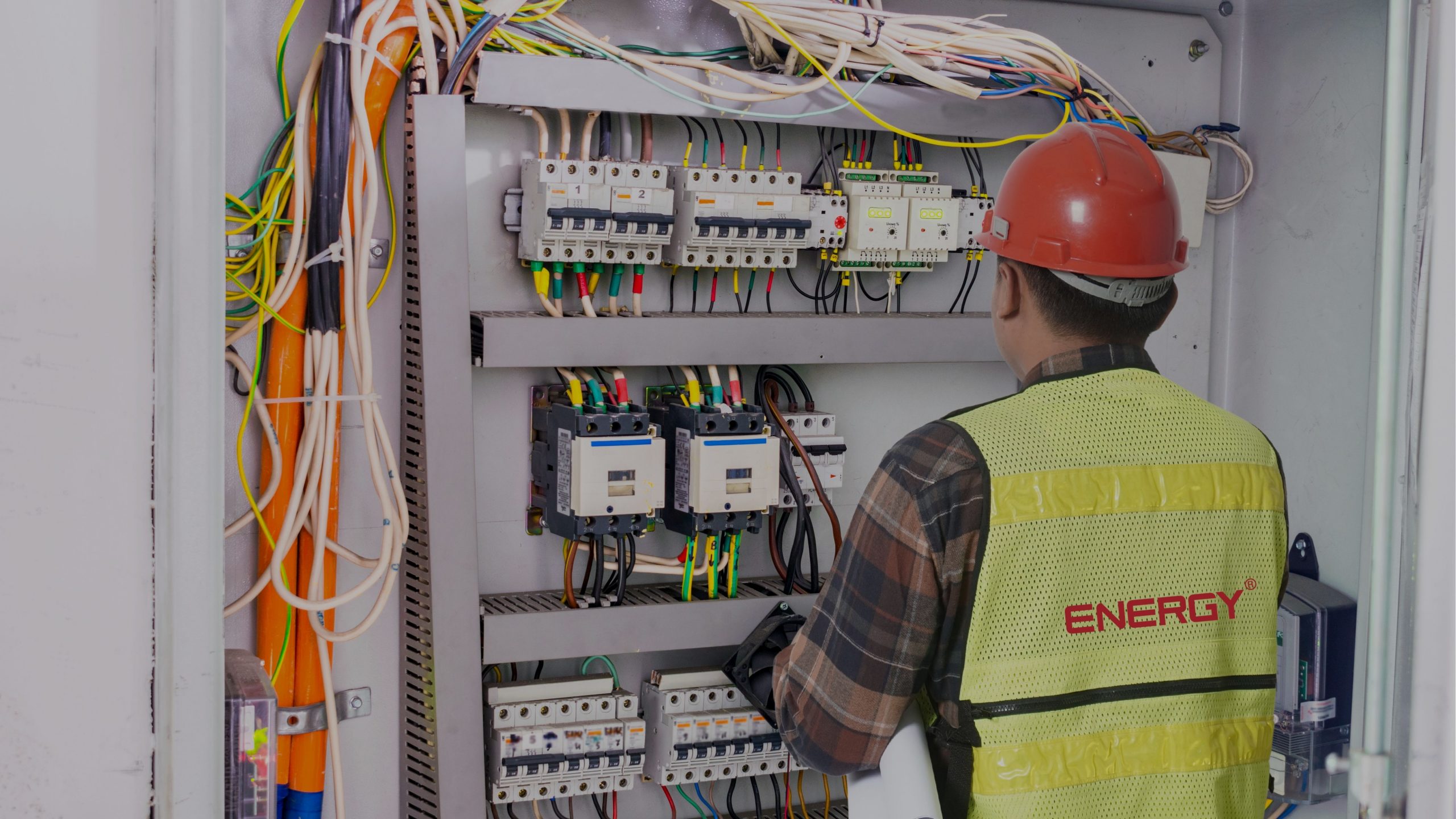 Ingenieros trabajando en un proyecto electromecánico industrial con integración eléctrica y mecánica dentro de una nave de manufactura.